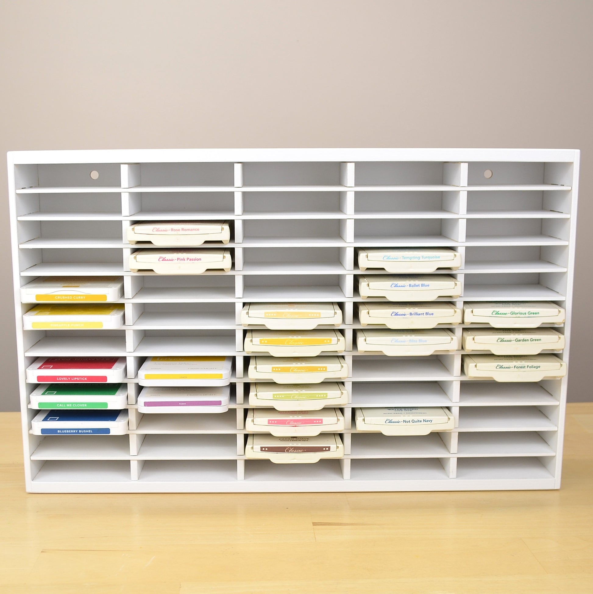 Front view of a white ink pad storage organizer holding Stampin Up pads. 