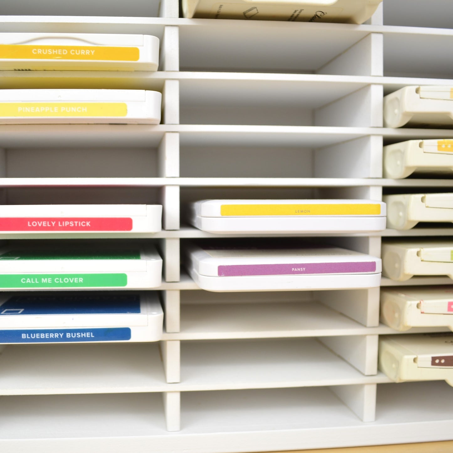 Closeup of Stampin Up and CTMH ink pads in a white storage organizer. 