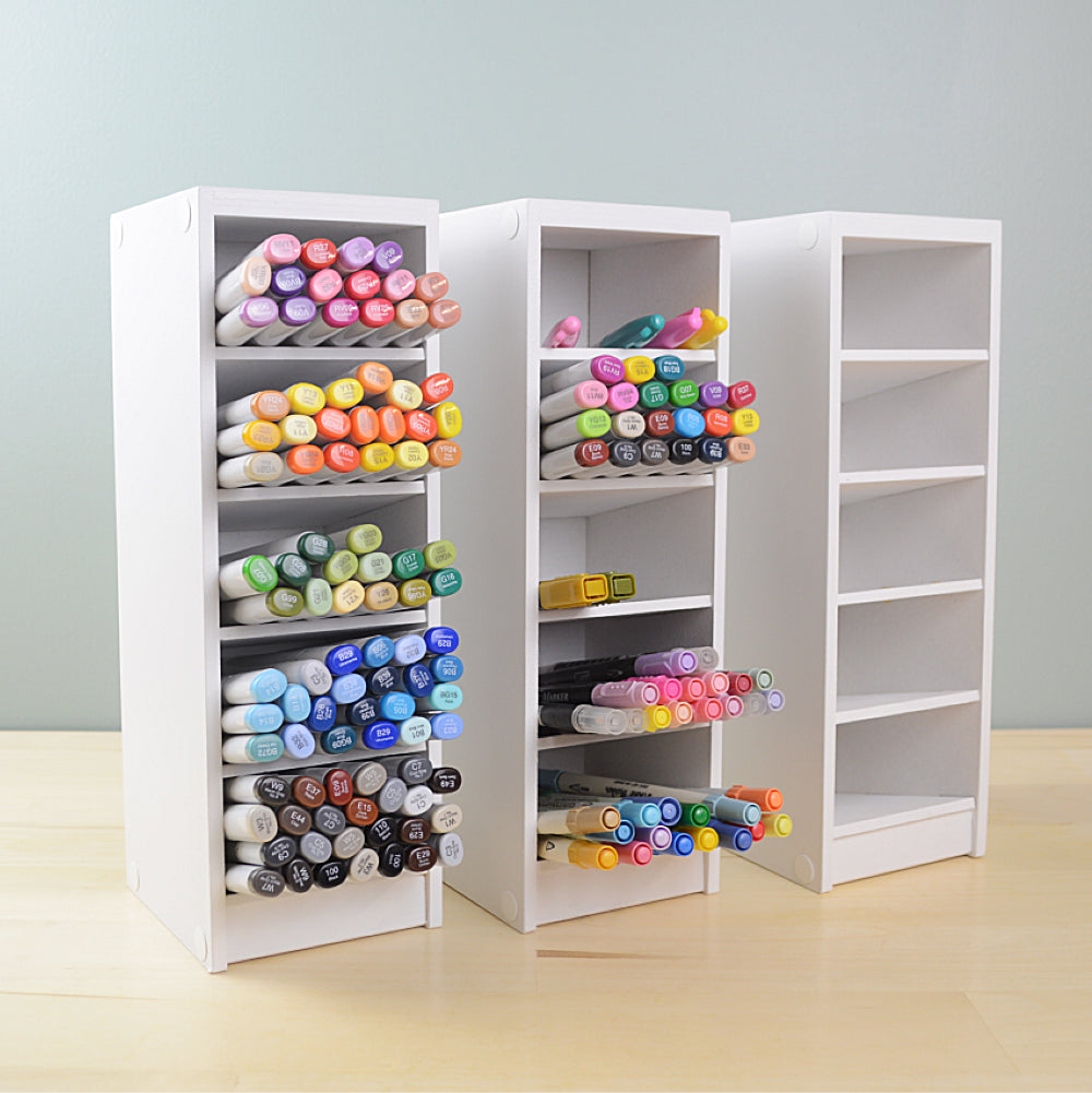 three white marker organizers standing side by side with colorful copic markers inside