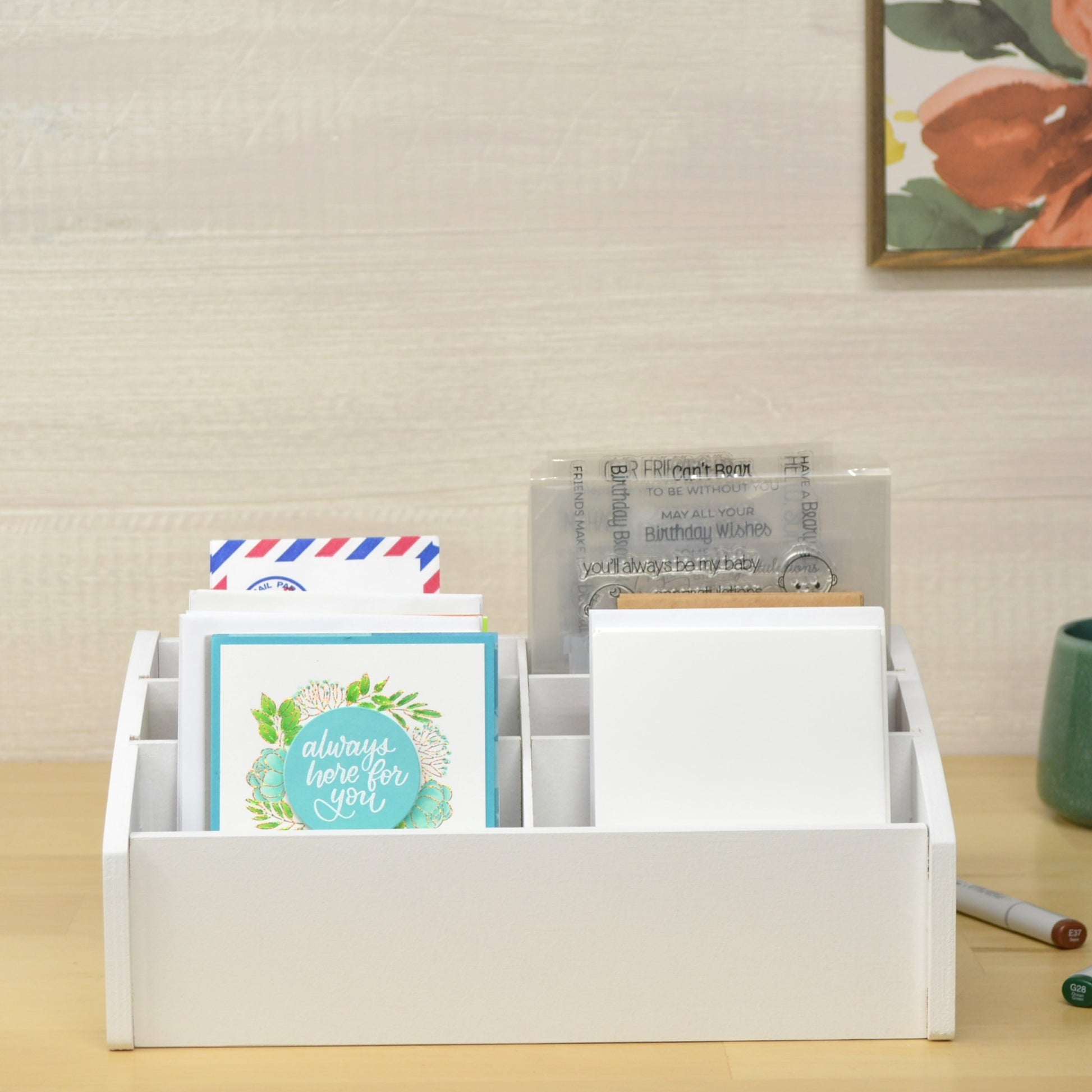 front view of handmade greeting cards in a white organizer on a wooden tabletop