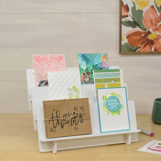 cute card stand displaying beautiful handmade cards on three shelves that are tiered