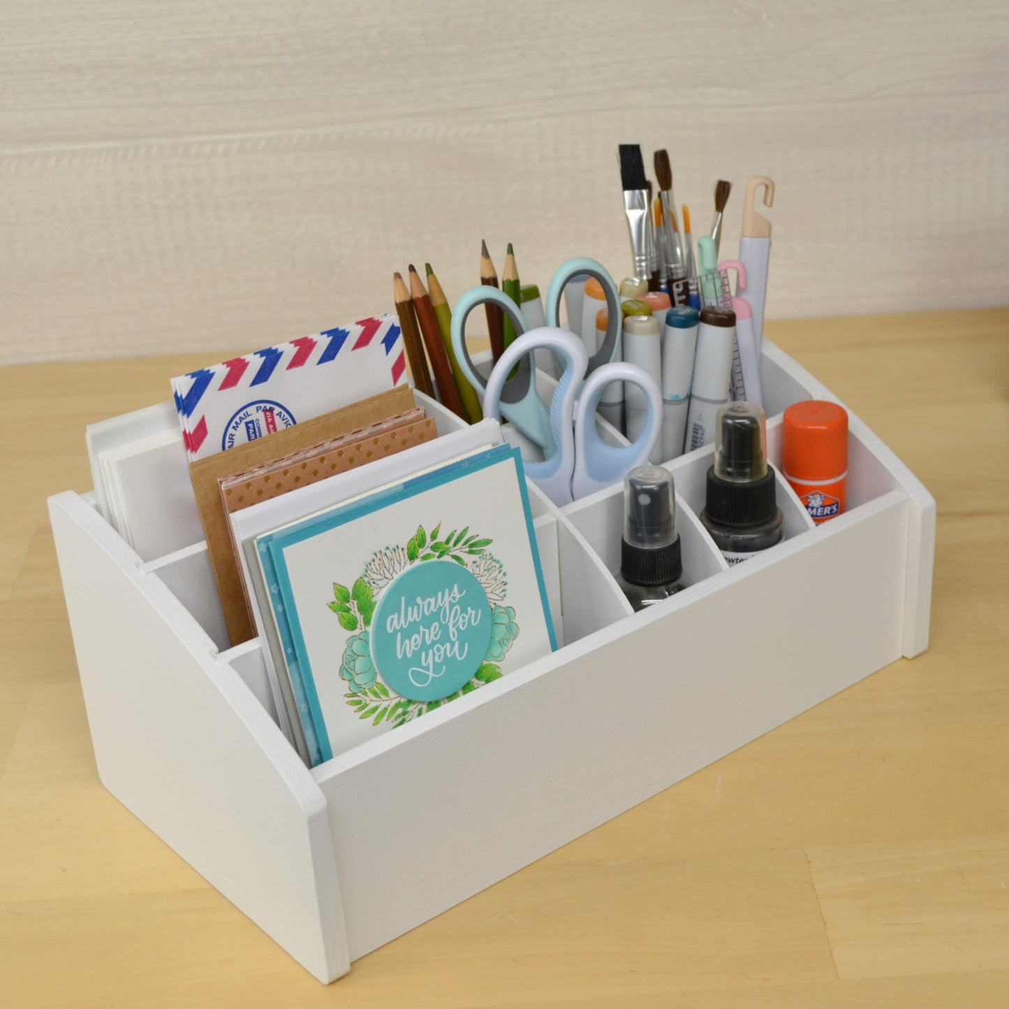 desk caddy painted white with greeting cards on the left side and craft tools on the right