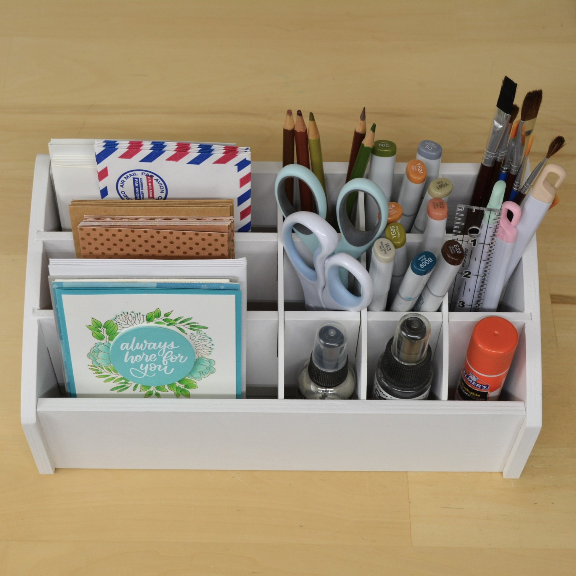 top view of an organizer holding greeting cards, pencils, markers, and paint brushes