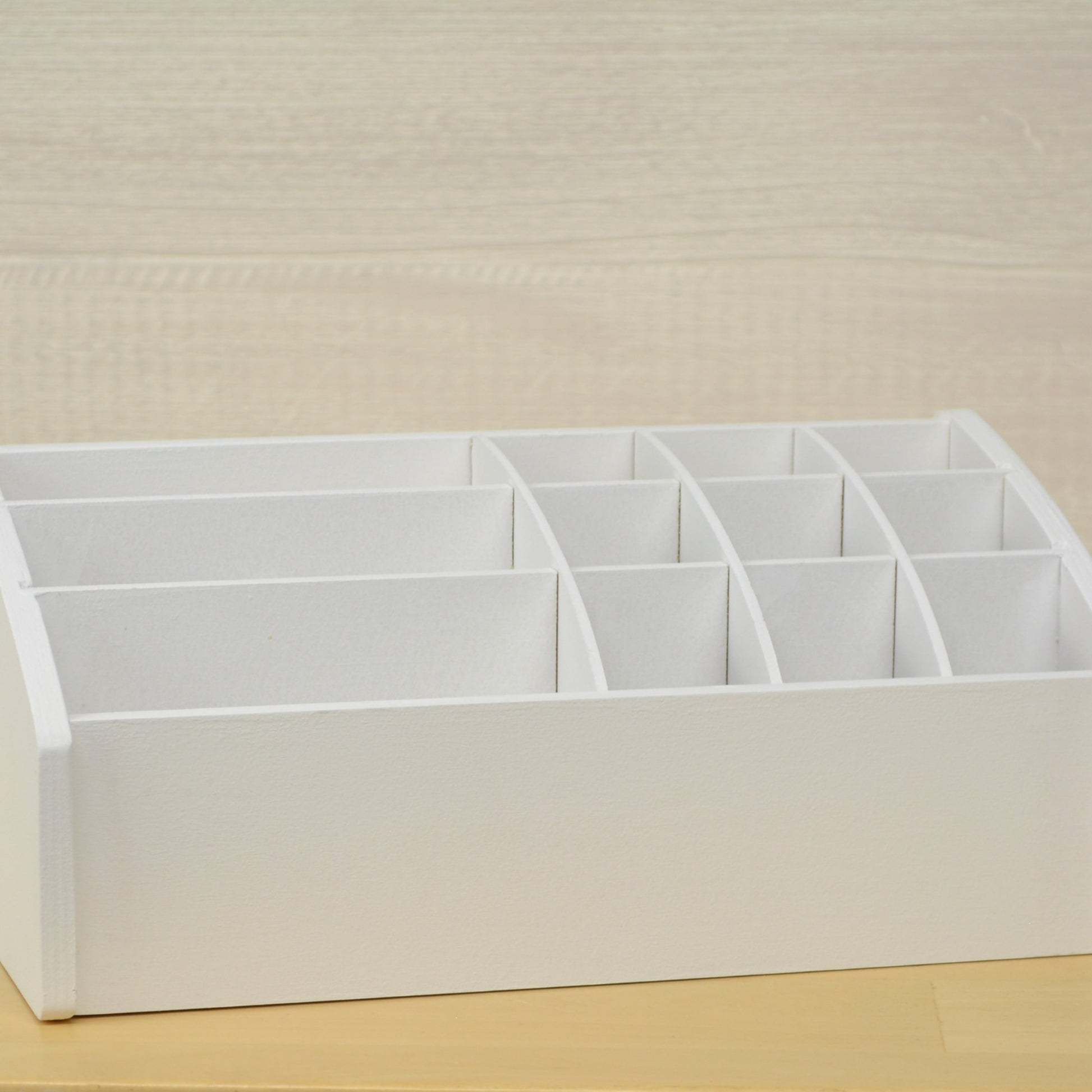 front view of a desk caddy with white dividers made to hold craft supplies