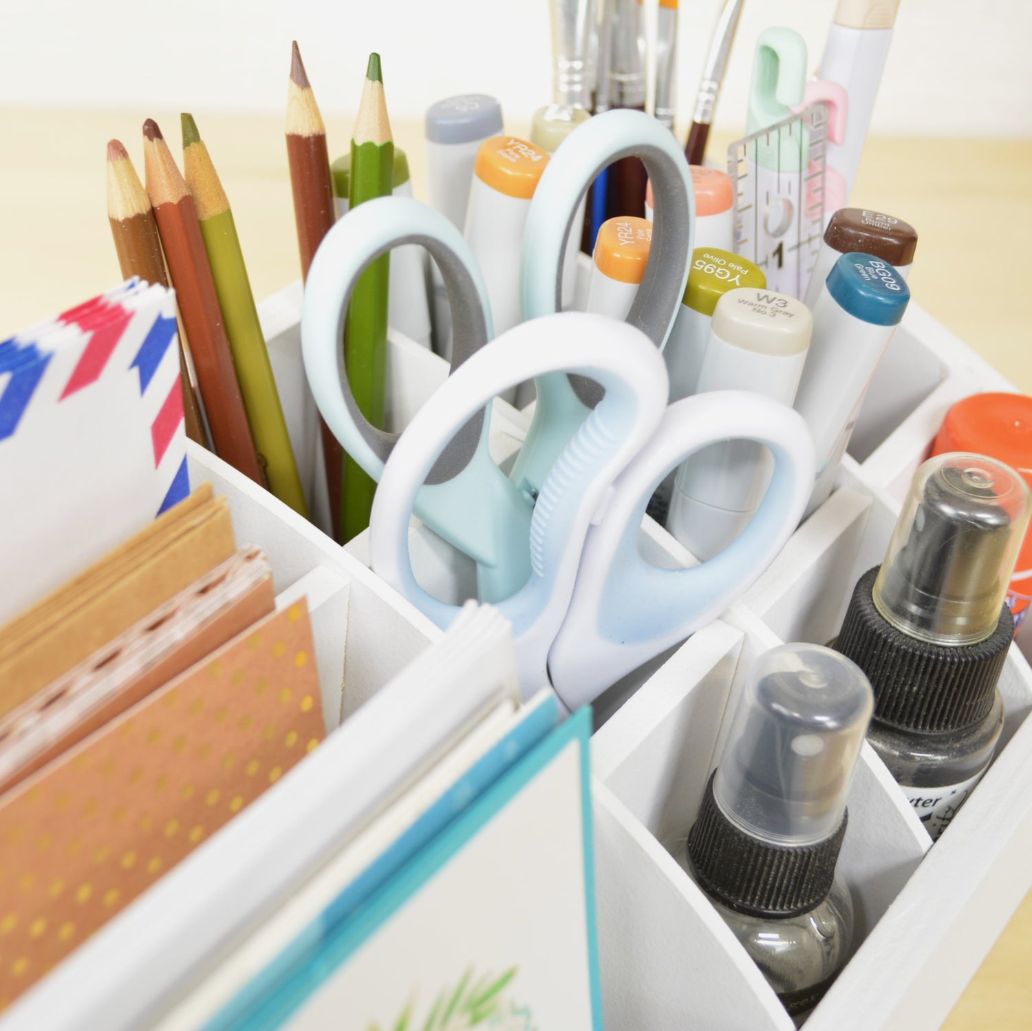 closeup of desk caddy cubbies holding scissors, markers, and rulers