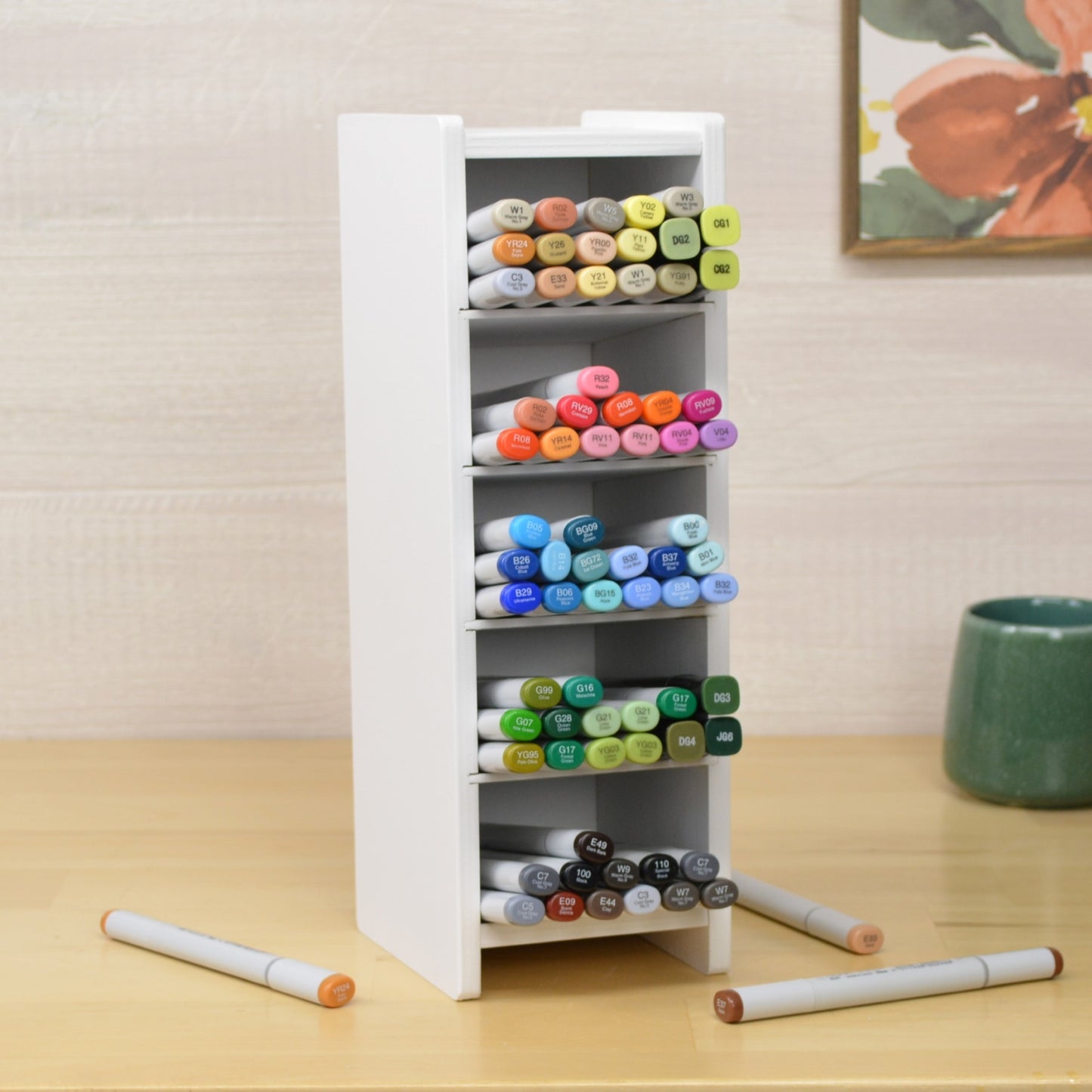 beautiful marker organizer holding copic markers painted white and placed on a wooden desktop