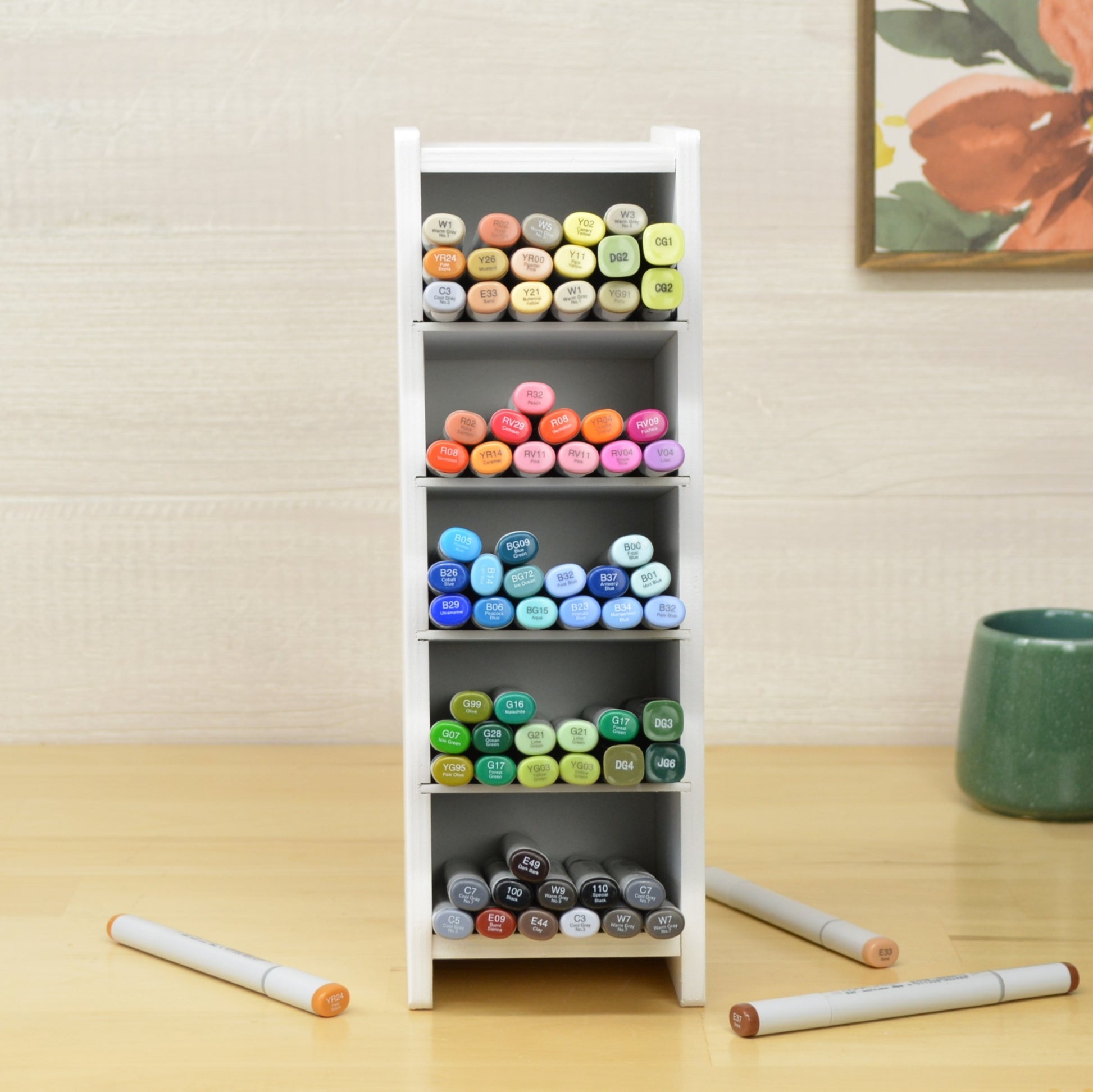 front view of a white organizer with five shelves full of copic markers