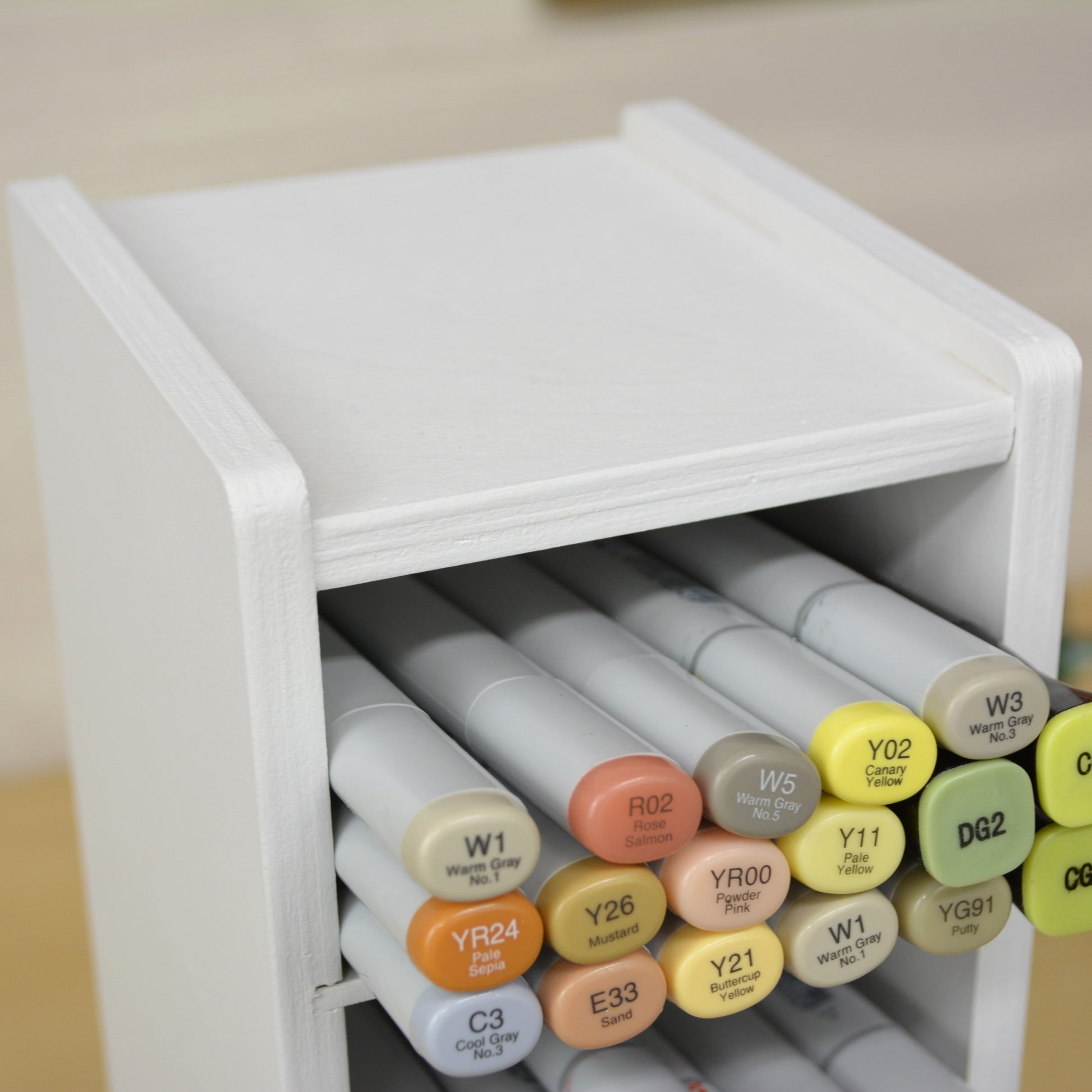 closeup showing top shape of a marker organizer and the top cubby filled with colorful copic markers