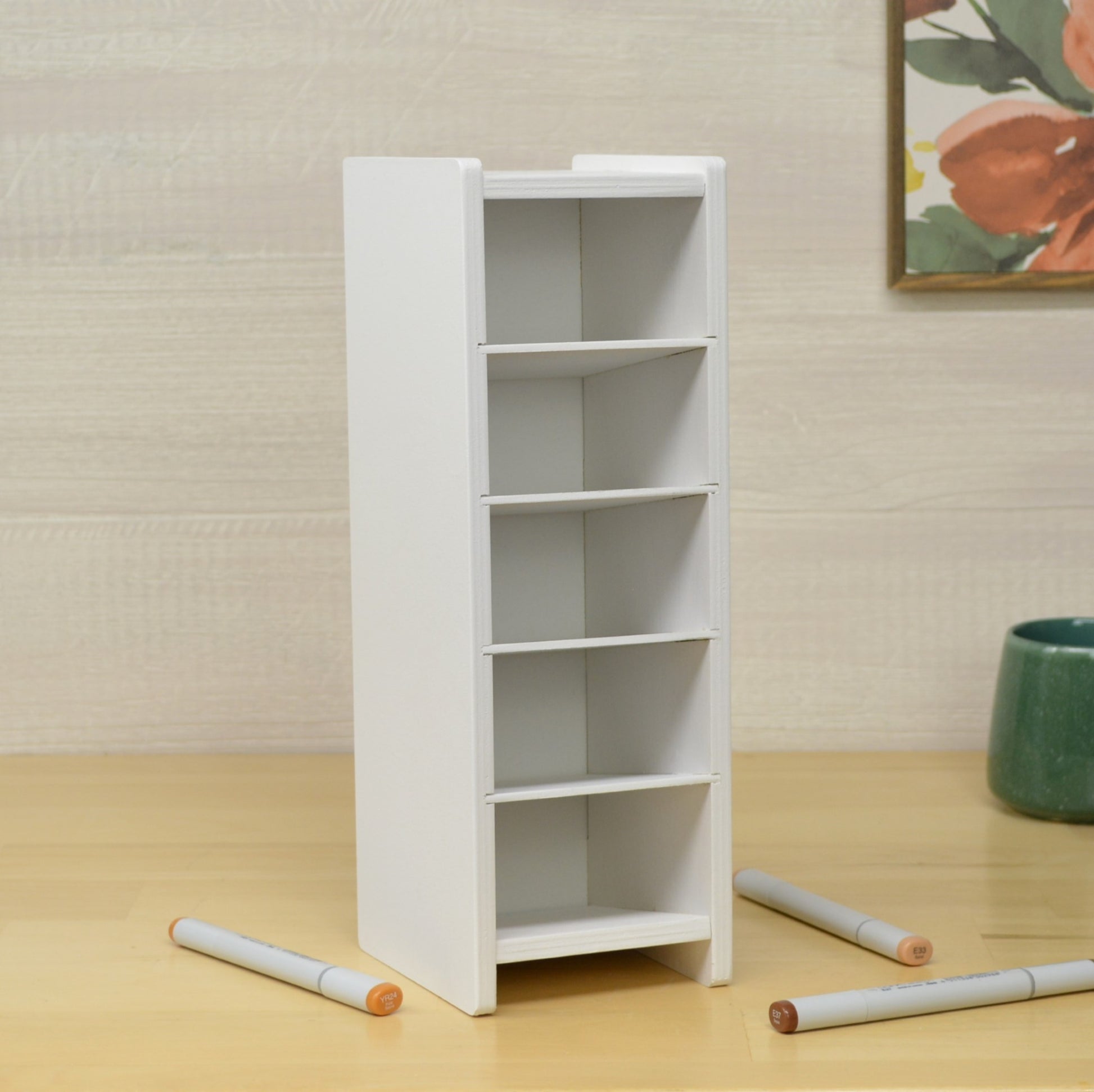 white empty marker organizer with five cubbies on a wooden work surface