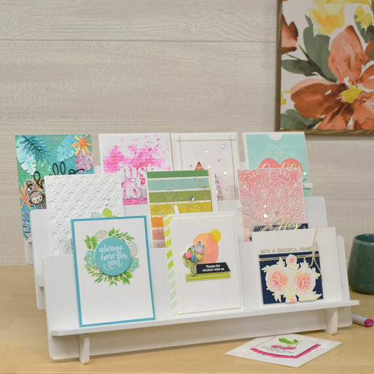 large greeting card stand displaying handmade cards on three tiers and painted white