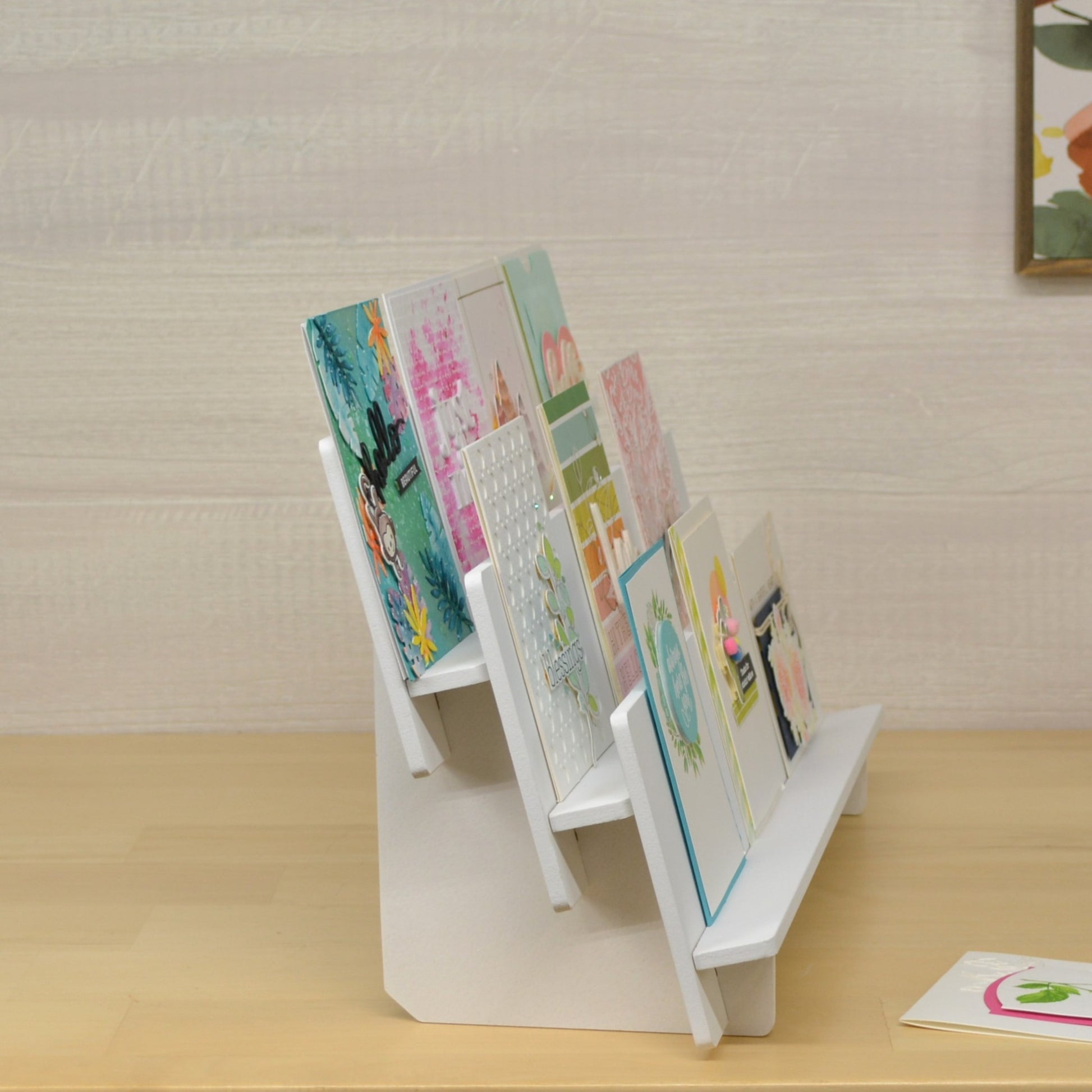 side view of a tiered shelf display with handmade greeting cards positioned on each level