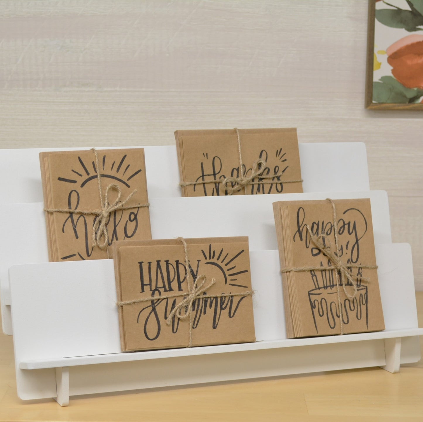 handmade cards tied in bundles with jute twine on a tiered  display shelf