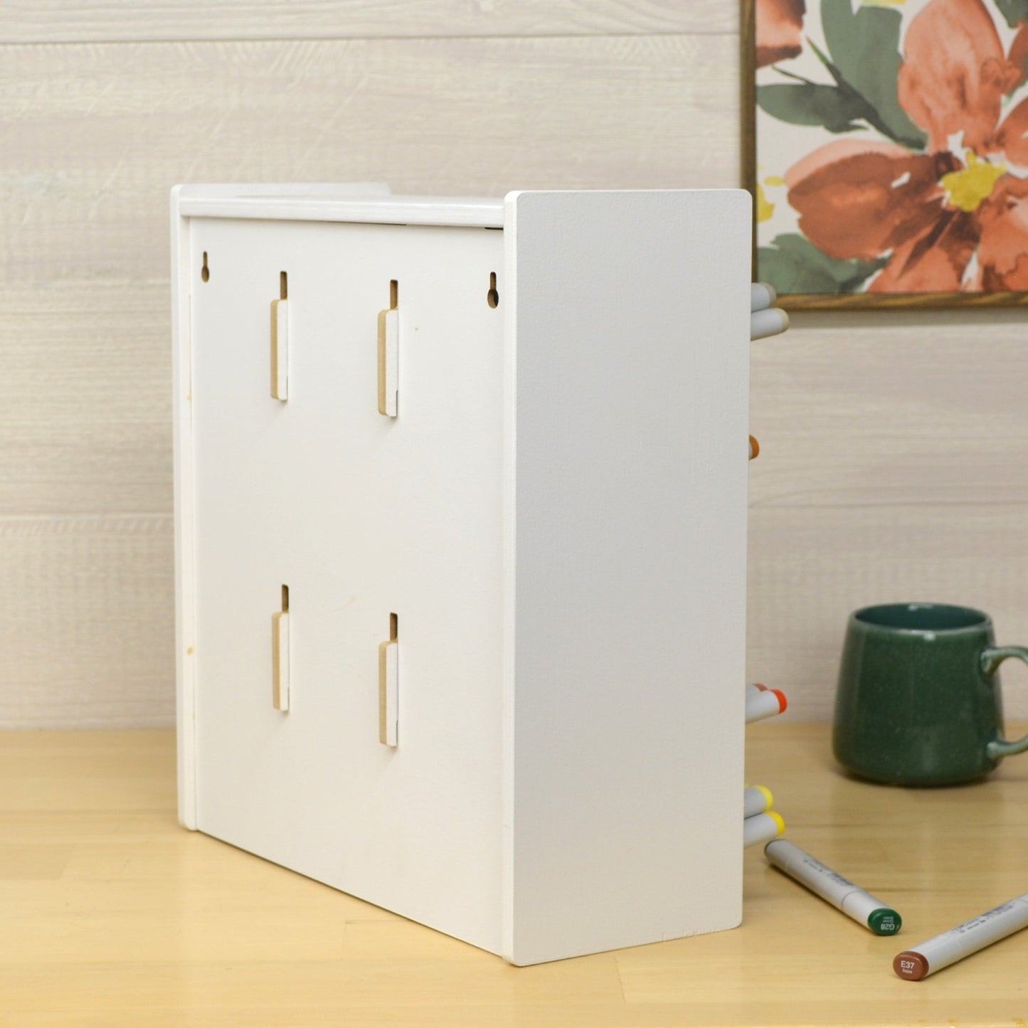 back view of a white marker organizer with keyholes for wall mounting