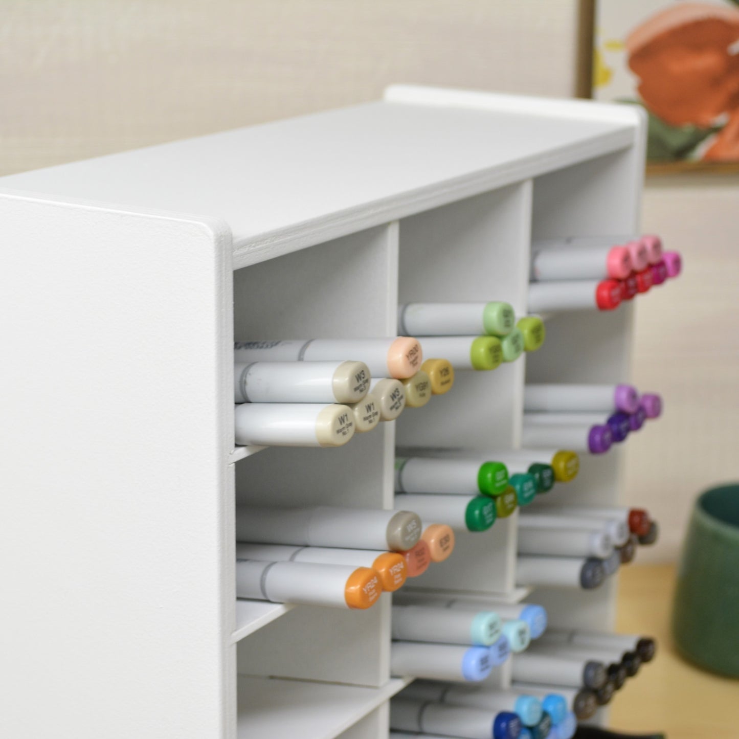 closeup of the top cubbies of a marker organizer holding copic markers