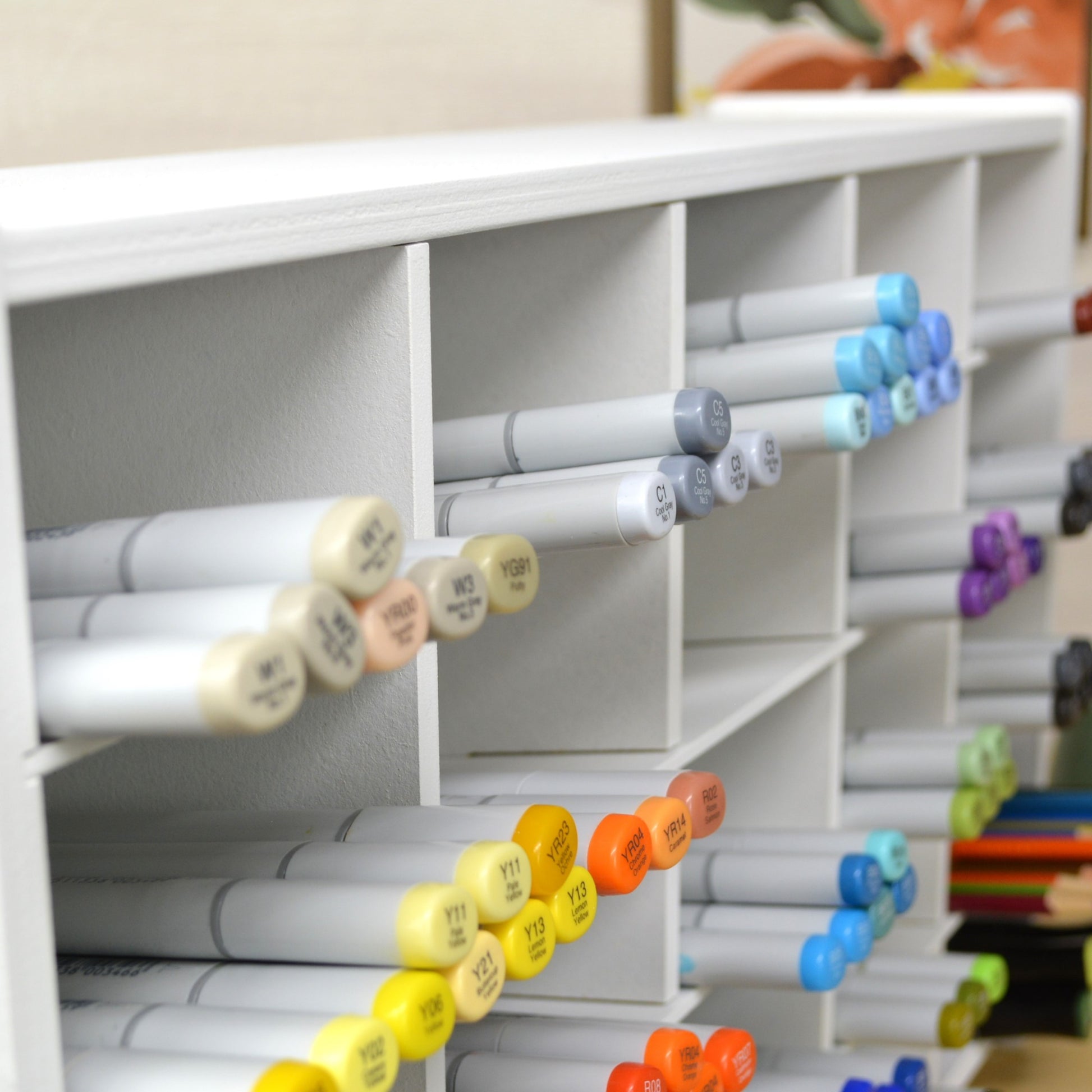 closeup side view of marker organizer showing the slanted angle of markers laying on the shelves