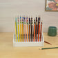 front view of a desktop pencil holder with colored pencils on a table