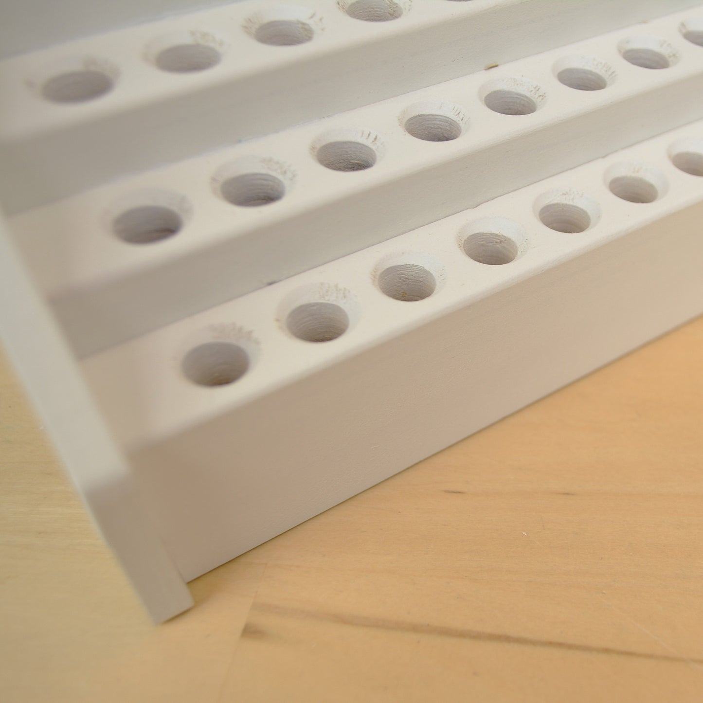 closeup of the beveled holes in a tiered pencil holder