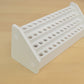 angle  view of a white wooden desktop pencil holder with forty eight holes